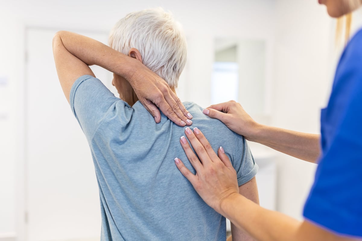 Physiotherapist doing healing treatment on woman's back. Back pain patient, treatment, Doctor consulting with patient Back problems Physical therapy concept