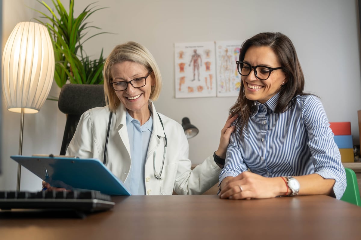 Smiling female doctor and beautiful woman meeting at hospital. Patient having appointment with doctor in hospital