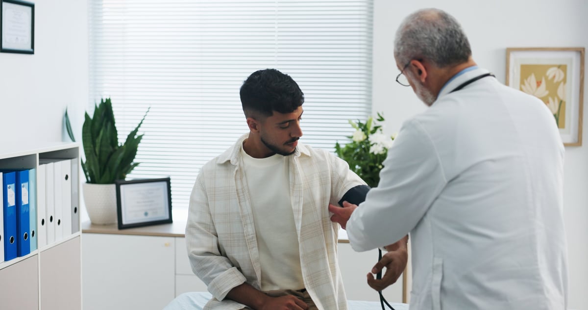 Blood pressure, consultation and doctor with man in hospital for medical service or support. Advice, checkup and healthcare worker with male patient for monitoring pulse with hypertension in clinic.
